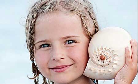 Small girl holding a shell