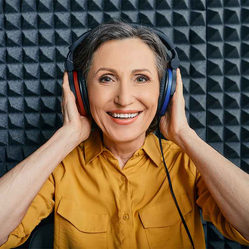 Woman in hearing booth having her hearing tested.