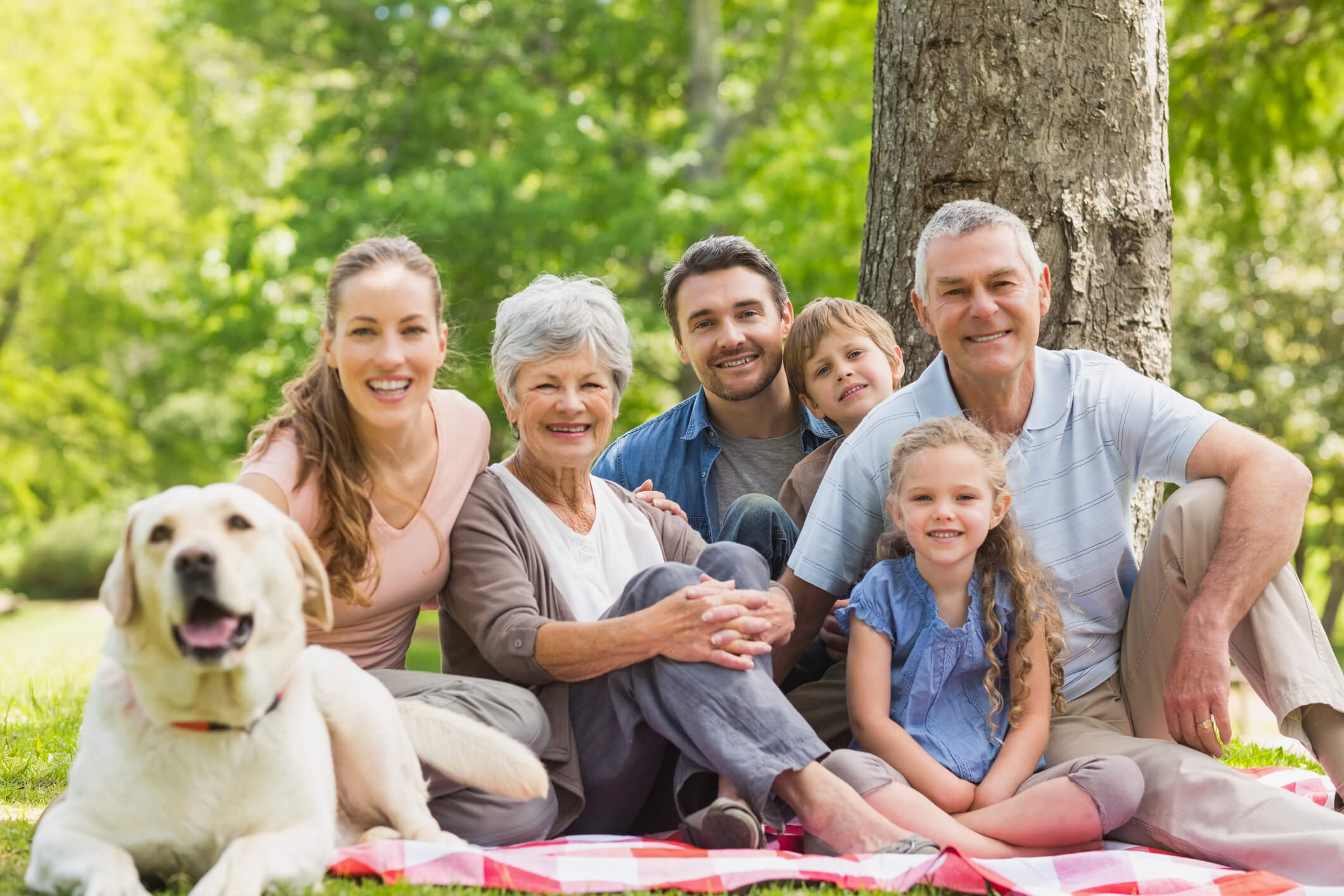 Family gathered together outside with a dog